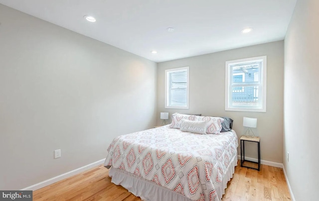 bedroom with baseboards, recessed lighting, and light wood-style floors