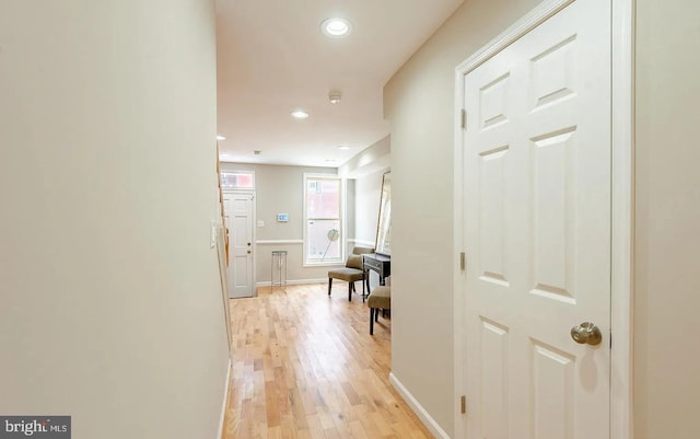 hallway with baseboards, light wood-type flooring, and recessed lighting