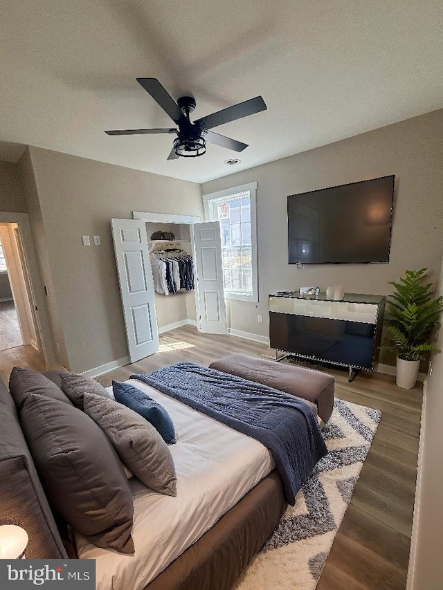 bedroom with a ceiling fan, baseboards, and wood finished floors