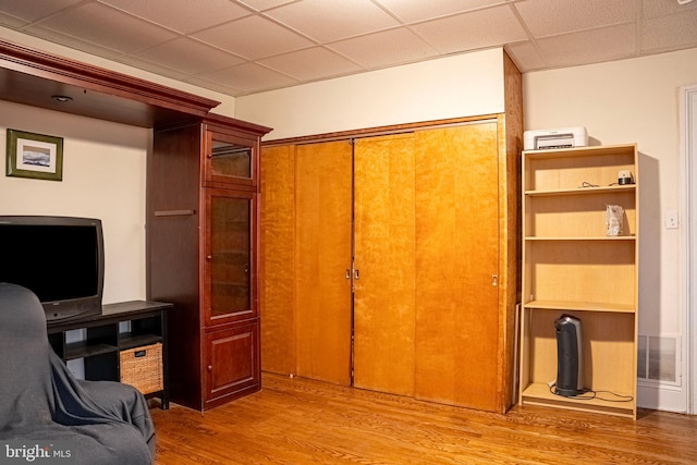 home office with visible vents, a drop ceiling, and wood finished floors