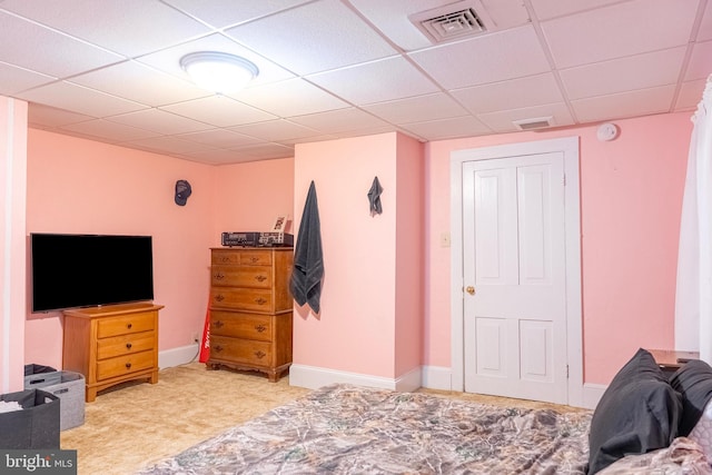 bedroom with a paneled ceiling, visible vents, and baseboards