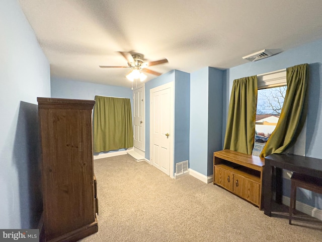 interior space with baseboards, visible vents, ceiling fan, and carpet flooring