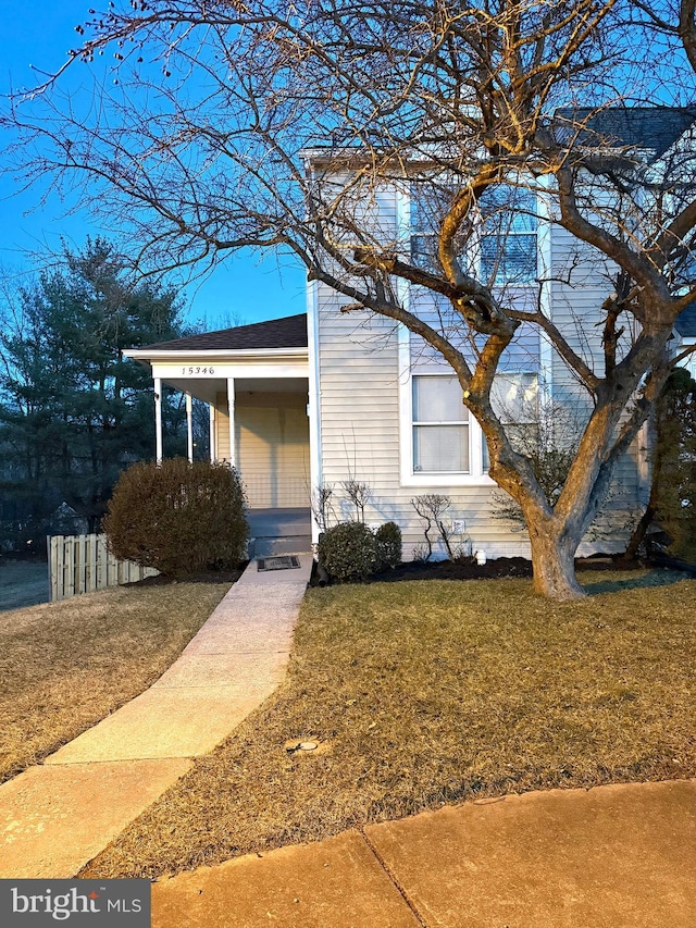 view of front of house with a front lawn, a porch, and a shingled roof