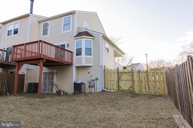 back of property with a fenced backyard, a yard, and central air condition unit