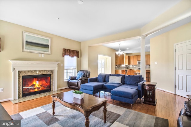 living area with a premium fireplace, baseboards, and hardwood / wood-style floors