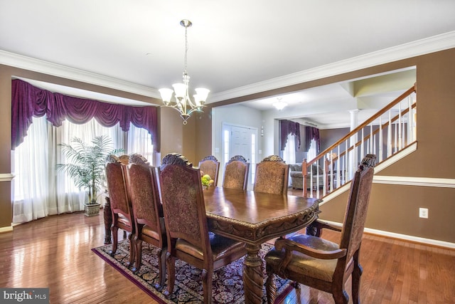 dining space featuring baseboards, crown molding, a chandelier, and hardwood / wood-style floors