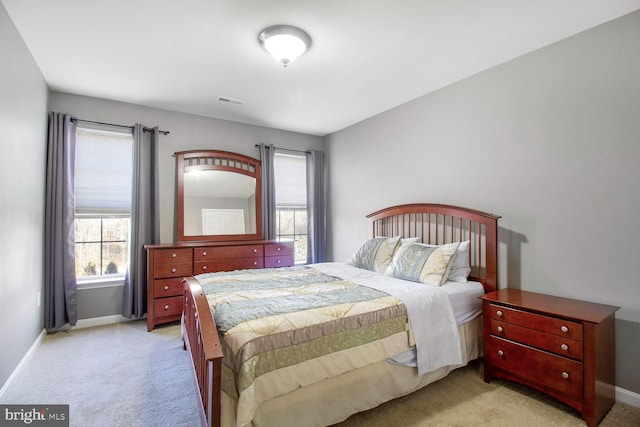 bedroom featuring visible vents, baseboards, and light colored carpet