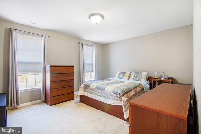 bedroom with light colored carpet, visible vents, and baseboards