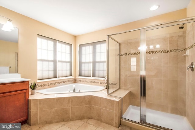 full bathroom with a stall shower, tile patterned flooring, a garden tub, and vanity