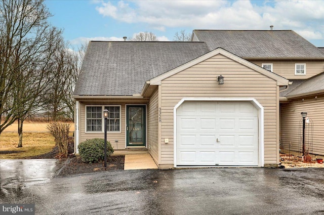 multi unit property with driveway, an attached garage, and a shingled roof