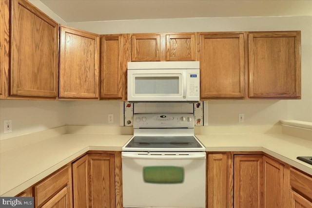 kitchen with white appliances, brown cabinets, and light countertops