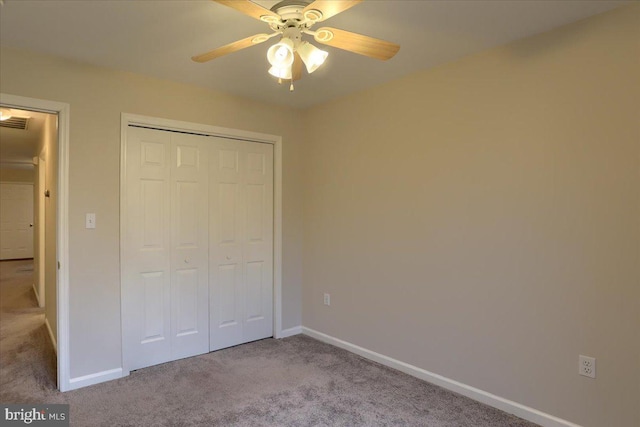 unfurnished bedroom with a closet, ceiling fan, baseboards, and carpet