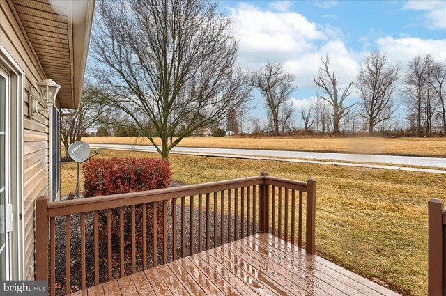 wooden deck featuring a lawn