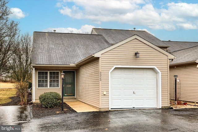 view of front of home with an attached garage, driveway, and roof with shingles