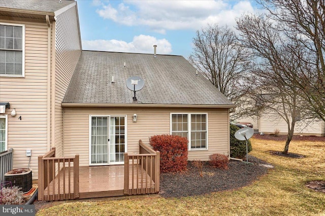 back of property with cooling unit, roof with shingles, and a deck