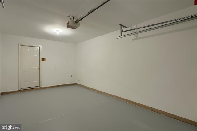 garage featuring a garage door opener and baseboards