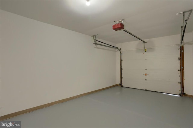 garage featuring a garage door opener and baseboards