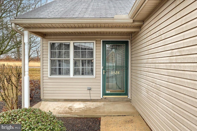 doorway to property featuring a shingled roof