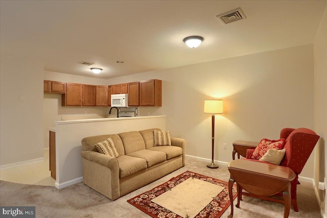 living room with visible vents, baseboards, and light carpet