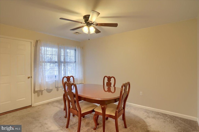 dining room with ceiling fan, light colored carpet, visible vents, and baseboards