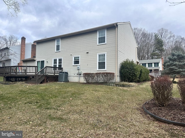 rear view of house with a wooden deck and a yard