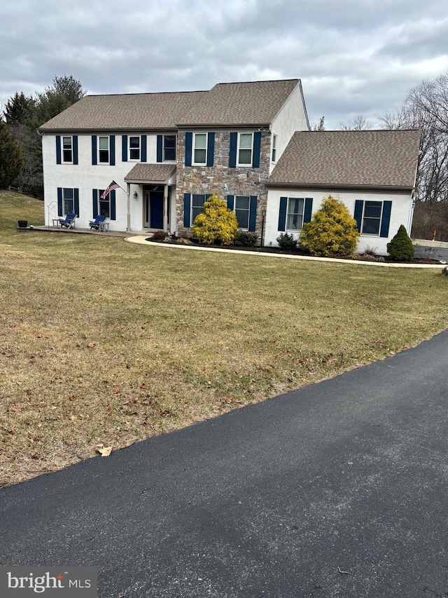 view of front of home with a front lawn and stone siding