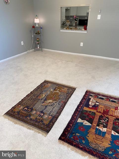carpeted living area featuring baseboards