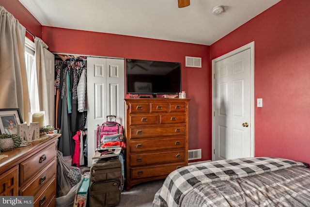 carpeted bedroom with a closet, visible vents, and a ceiling fan