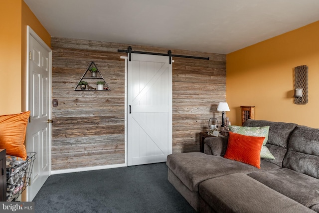 living room with an accent wall, a barn door, wood walls, and carpet