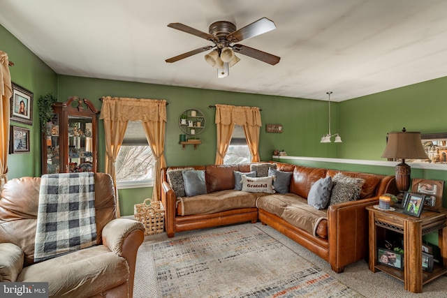 carpeted living area with ceiling fan