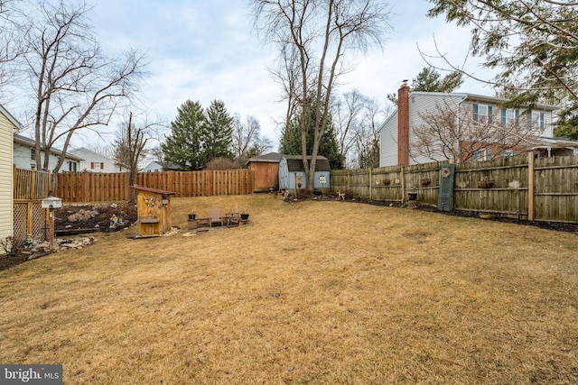 view of yard with a storage shed, an outdoor structure, and a fenced backyard