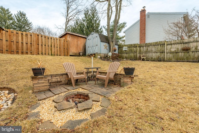 view of yard featuring a shed, a patio, a fenced backyard, and an outbuilding