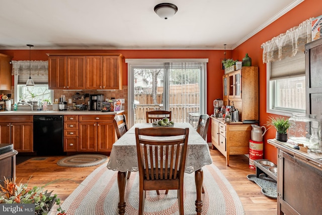 kitchen featuring a sink, light countertops, light wood-type flooring, dishwasher, and brown cabinetry