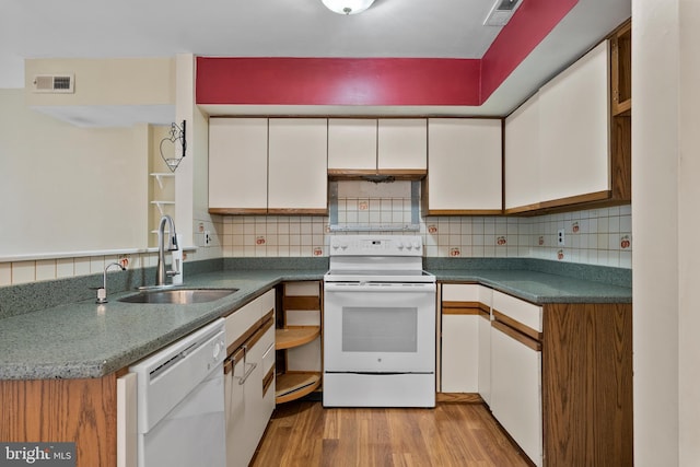 kitchen featuring white appliances, visible vents, a sink, and white cabinets