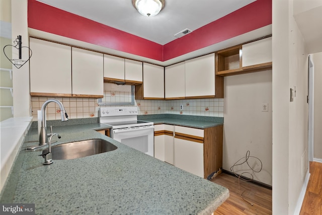 kitchen featuring light wood-style flooring, a sink, visible vents, white cabinetry, and white electric range oven