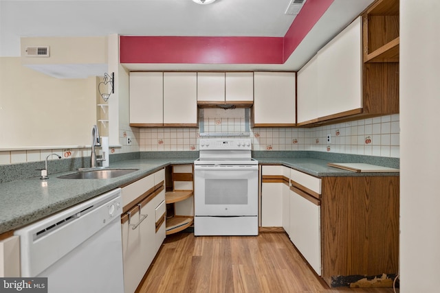 kitchen with visible vents, backsplash, white cabinets, a sink, and white appliances