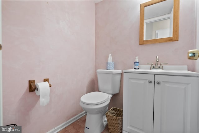 half bath featuring baseboards, vanity, toilet, and tile patterned floors