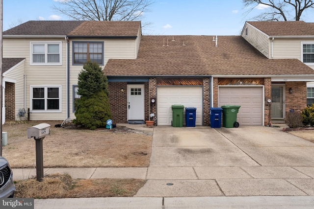 townhome / multi-family property featuring a garage, concrete driveway, a shingled roof, and brick siding