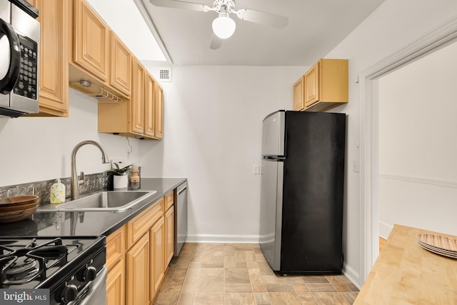 kitchen with a sink, visible vents, baseboards, appliances with stainless steel finishes, and light brown cabinetry