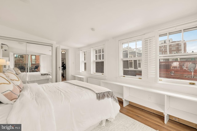 bedroom with vaulted ceiling and wood finished floors