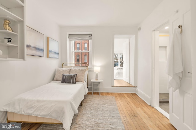 bedroom featuring baseboards and hardwood / wood-style flooring