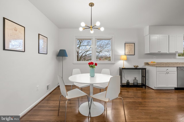 dining space featuring dark wood-style floors, an inviting chandelier, and baseboards