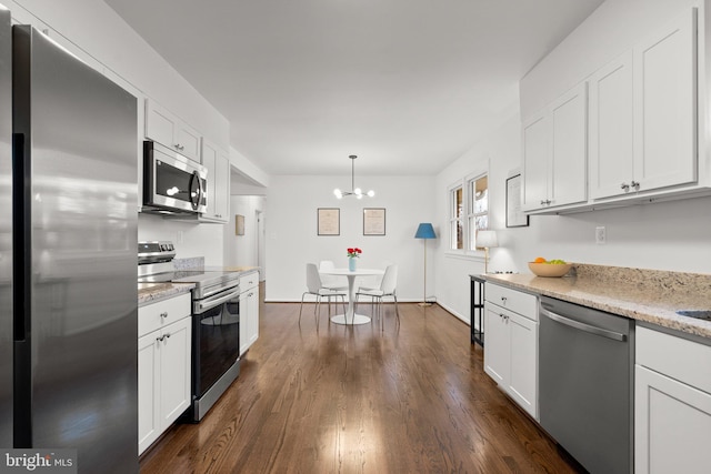 kitchen with stainless steel appliances, dark wood-type flooring, white cabinetry, and light stone countertops