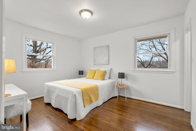 bedroom with multiple windows, baseboards, and dark wood-style flooring