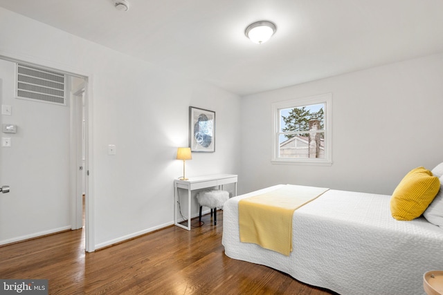 bedroom featuring baseboards, visible vents, and wood finished floors