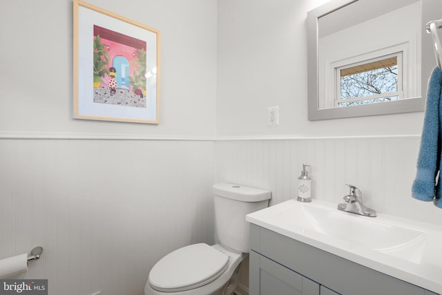 bathroom featuring wainscoting, vanity, and toilet