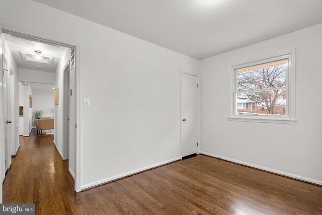 interior space featuring attic access, baseboards, and wood finished floors