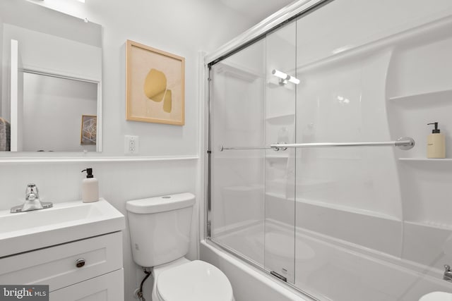 bathroom with vanity, toilet, and bath / shower combo with glass door