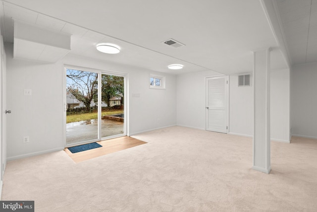 basement with carpet, visible vents, and baseboards