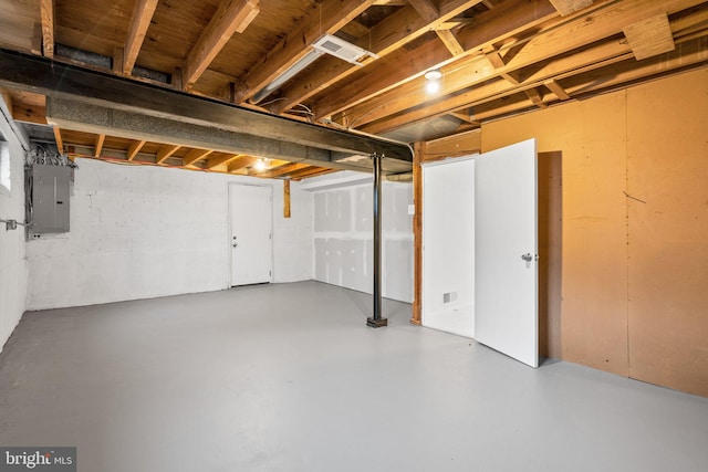 unfinished basement with electric panel and visible vents